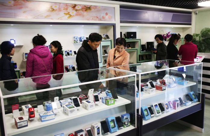 North Koreans peruse cell phones on offer