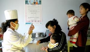 A medic administers a vaccination to a child in North Korea