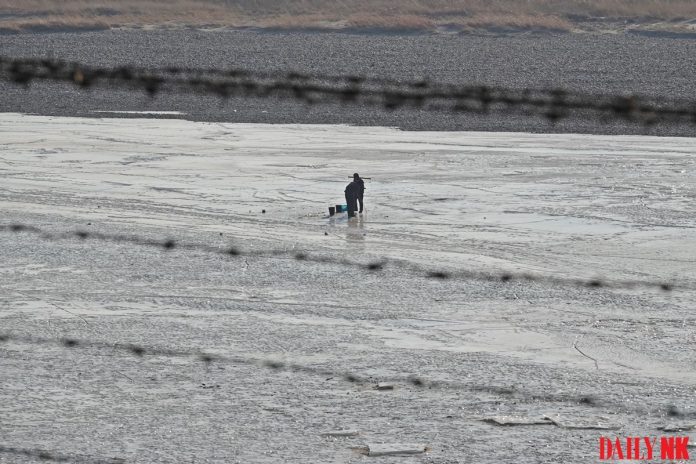DSC01774 A North Korean resident in Onsong County, North Hamgyong Province draws water from the frozen river in March 2019