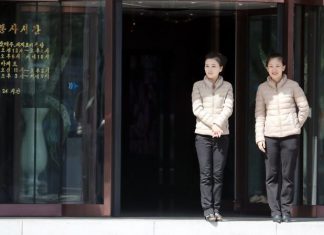 Two women standing in front of a coffee shop.