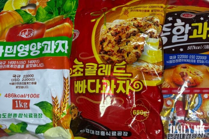 Three bags of North Korean factory-made candy and cookies, with packaging showing branding from Mangyongdae Kyonghung Food Factory and Songdowon Comprehensive Food Factory.