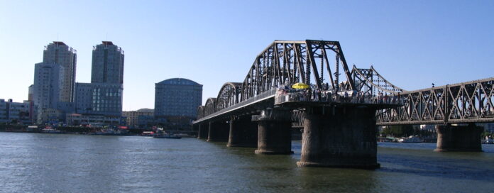 View of Dandong from the North Korean bank of the Yalu River, with the Yalu River Broken Bridge and Sino-Korean Friendship Bridge visible.