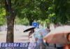 North Koreans walk along a tree-lined street shielding themselves from the heat with parasols in a screen grab from a Korean Central Television broadcast on July 10, 2025.