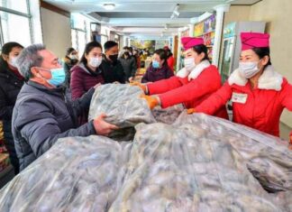 Pyongyang residents receive bags of fish at a state-run store after leader Kim Jong Un ordered thousands of tons of fish distributed to the capital, Dec. 21, 2021.