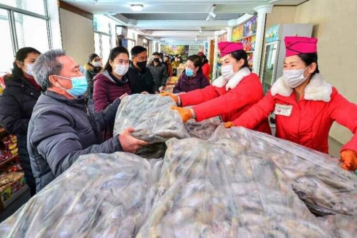 Pyongyang residents receive bags of fish at a state-run store after leader Kim Jong Un ordered thousands of tons of fish distributed to the capital, Dec. 21, 2021.