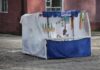 A vendor sits at a street stall selling Gangseo mineral water in Pyongyang, North Korea