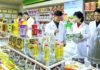 Workers in white lab coats inspect food products on display at the Amnok River General Food Factory in North Korea.