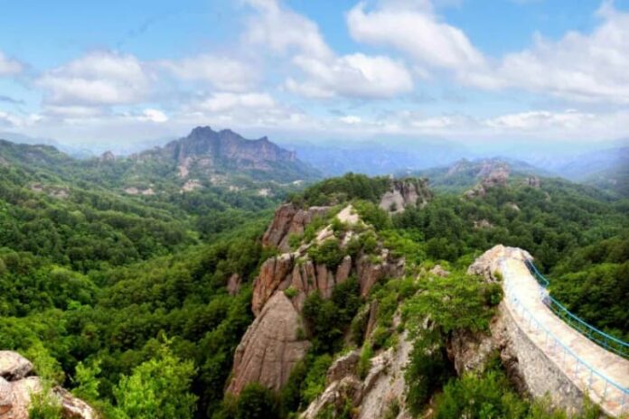 A panoramic view of Chilbo Mountain in North Hamgyong province, North Korea, showing forested rocky peaks and a walkway along a ridge.