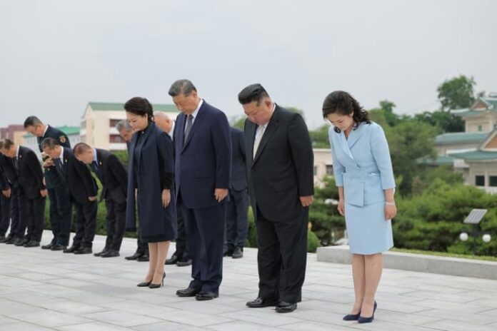 Kim Jong Un and Xi Jinping bow with their wives at the Friendship Tower in Pyongyang during the June 2026 visit at the center of the Kim Ju Ae succession debate.