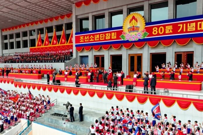 Children's Honor Award ceremony backdrop as Korean Children's Union members celebrate the organization's 80th anniversary with Kim Jong Un