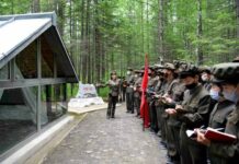 A lecturer addresses a visiting delegation at a revolutionary historic site in North Korea's Mount Paekdu area during a summer tour