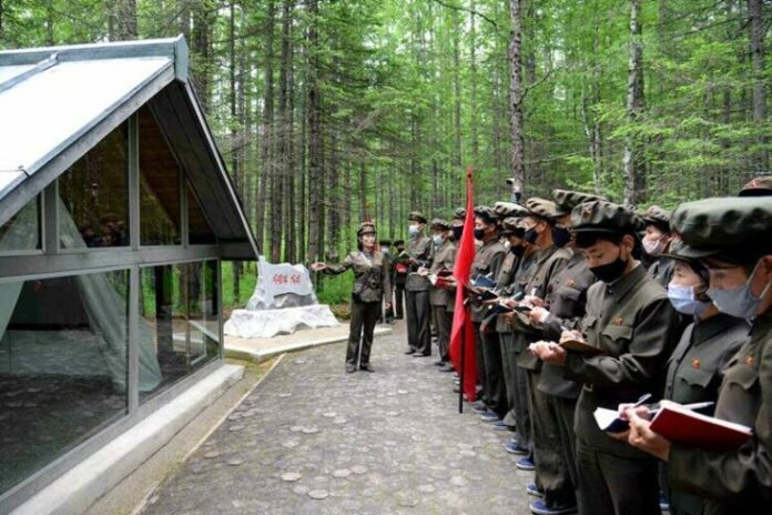 A lecturer addresses a visiting delegation at a revolutionary historic site in North Korea's Mount Paekdu area during a summer tour
