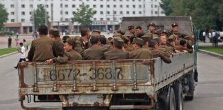 North Korean military families article image showing Korean People's Army soldiers riding in the bed of a truck