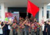 Young volunteers from North Pyongan province depart for construction assignments, carrying a red flag and flower garlands, in a send-off ceremony