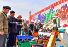 North Korean officials inspect construction equipment at a rural housing construction site