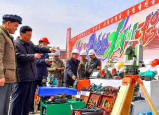 North Korean officials inspect construction equipment at a rural housing construction site