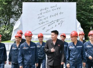 What’s behind North Korea’s coal industry push? Hard-hatted miners in front of an inscribed stone monument at the 2.8 Jikdong Youth Coal Mine