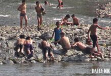 North Koreans face heatstroke and robbery in the same breath Boys swim and rest along a rocky riverbank on the Yalu River near Hyesan, Ryanggang province