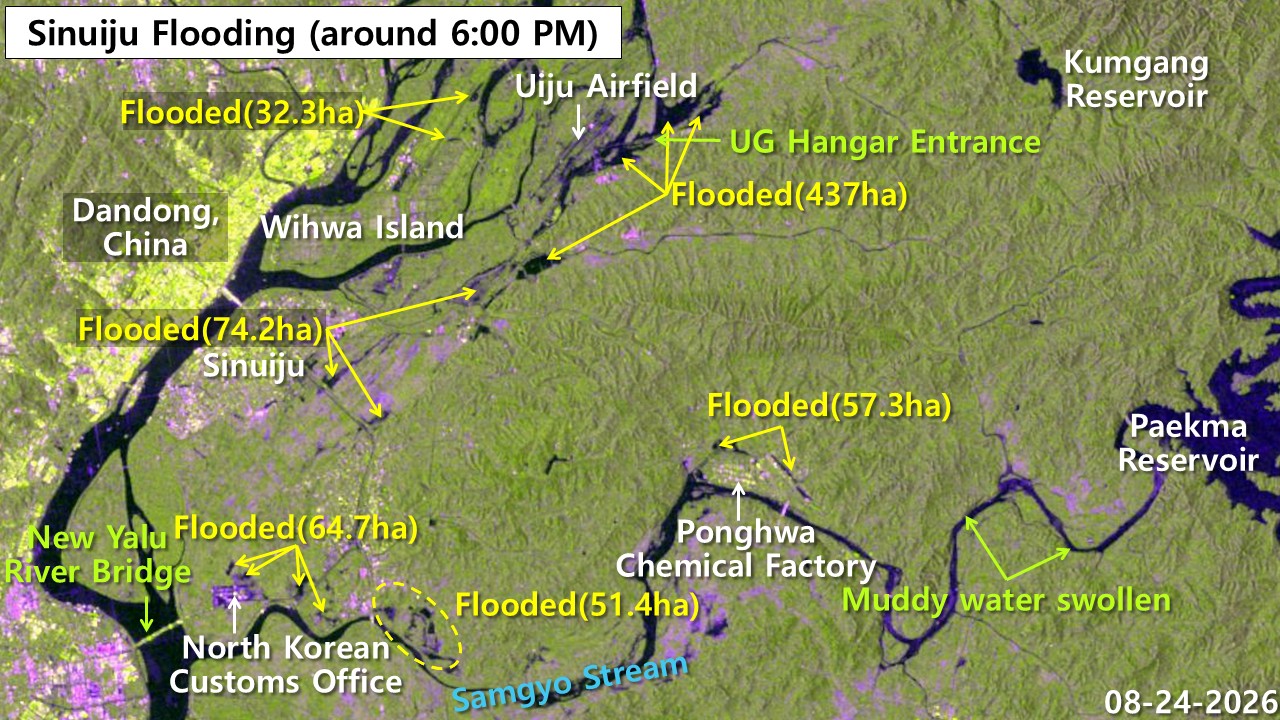 Satellite radar image of Sinuiju flooding on Aug. 24, 2026 showing flooded areas marked in yellow and magenta across Uiju Airfield, Bongwha Chemical Factory, customs office and Sinuiju city, with geographic landmarks including Dandong China, Wihwa Island, Kumgang Reservoir and Samgyochon Stream labeled.