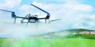 Agricultural drone spraying pesticide over a rice paddy in North Korea