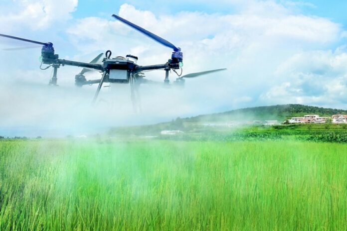 Agricultural drone spraying pesticide over a rice paddy in North Korea